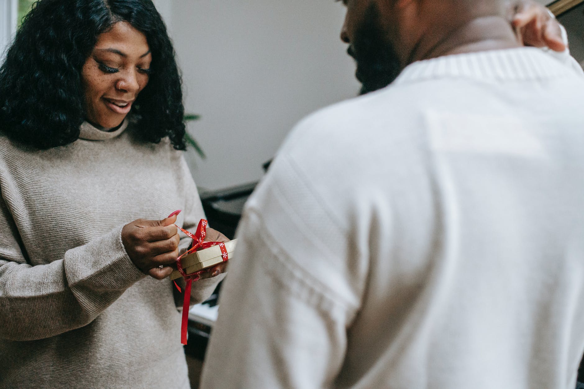 black couple in sweaters congratulating each other on christmas