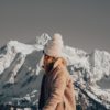 woman looking behind her at the snow covered steep mountains